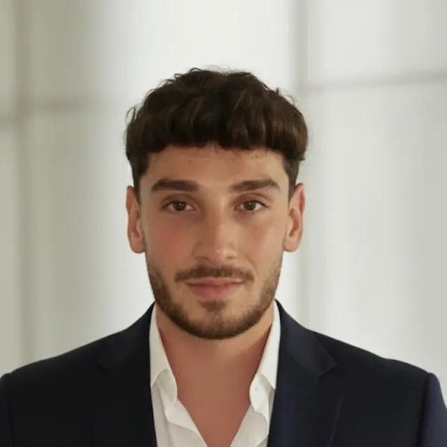 Land Flip Training founder Alex Mineo wears a blazer and stares stoically into the camera. 