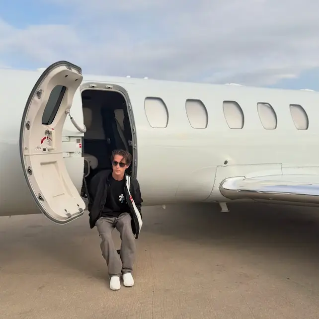 Closing Cabal creator Hudson Cosper sits on the steps of a private jet.